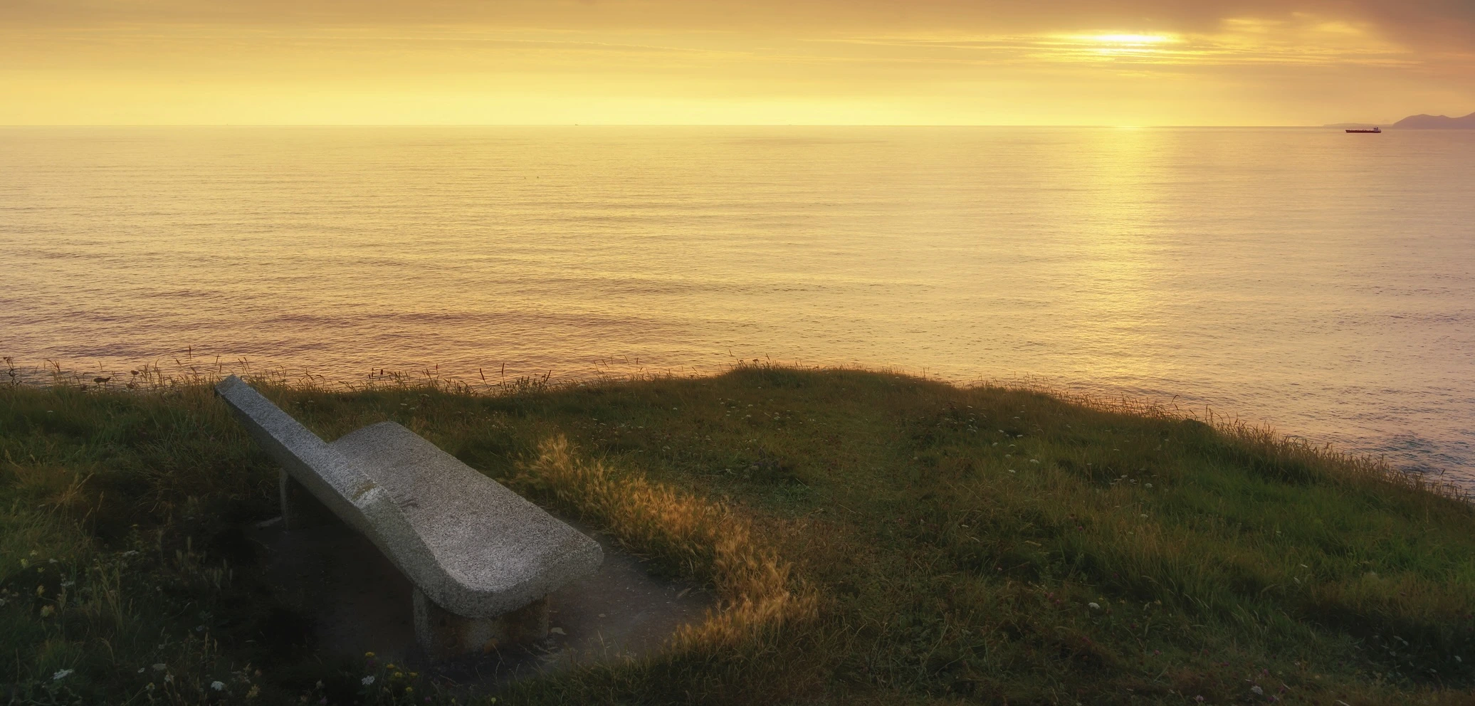 Zu sehen ist eine Bank am Meer / Zwischen Glaube und Zweifel / Zwischenzeilen