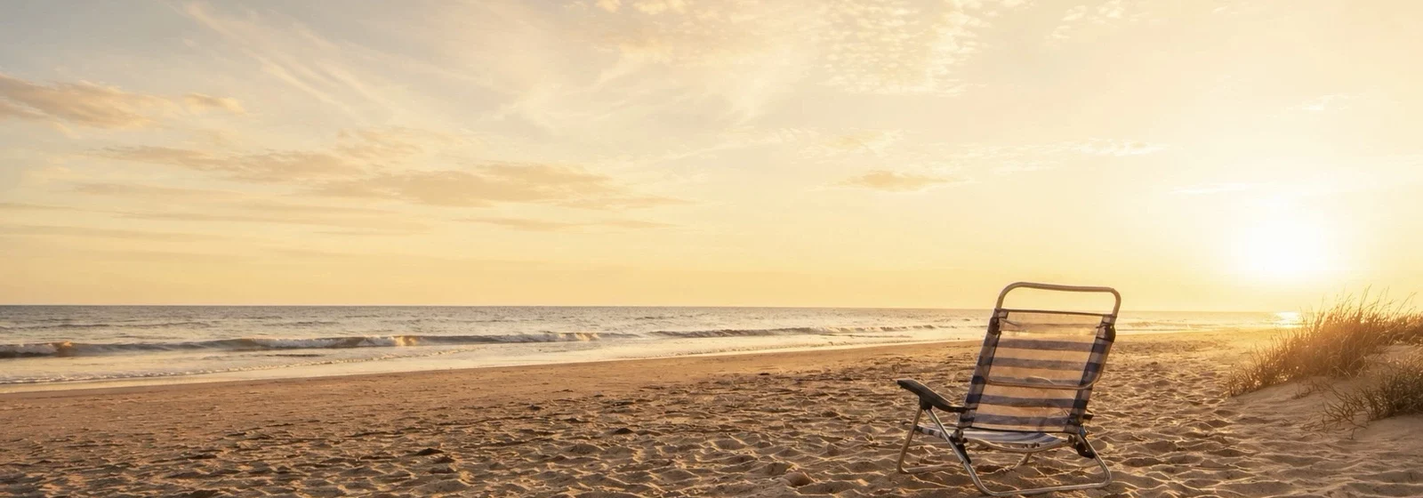 Zu sehen ist ein Campingstuhl am Strand / Innehalten