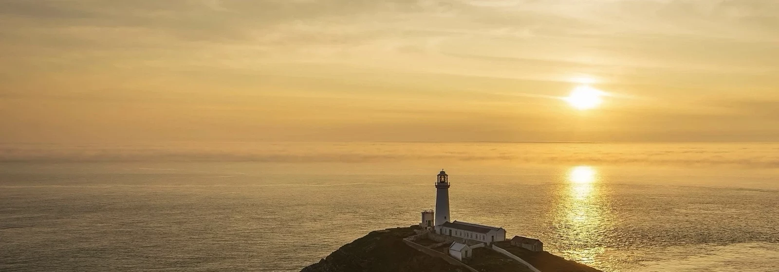 Zu sehen ist ein Leuchtturm und das weite Meer / Leuchtturm