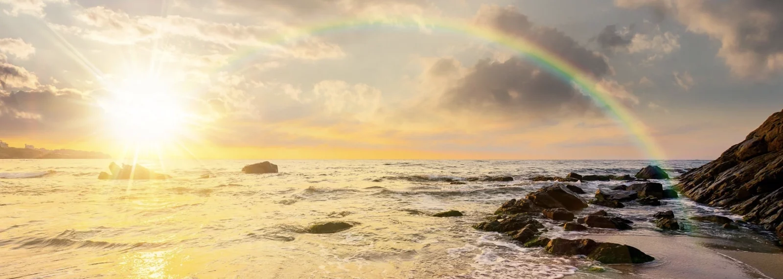 Zu sehen ist ein Regenbogen über dem Meer / Vergebung